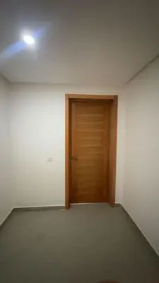 an empty room with a wooden door and a light at dekra bouznika in Bouznika