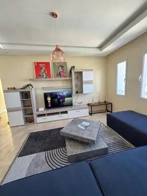 a living room with a couch and a tv at Apartment with pool view, 1 min to beach, private parking in Pont Blondin