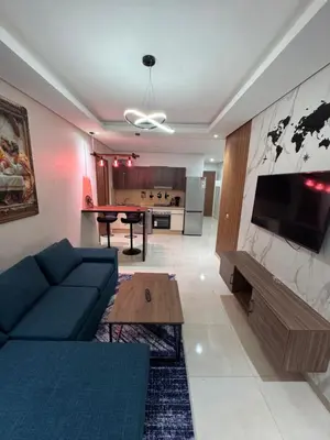 a living room with a couch and a table at Cosy appart hotel Bouznika in O Ben Slimane
