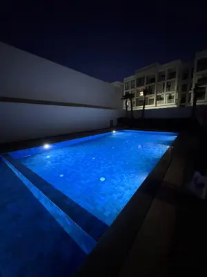 a swimming pool at night on a building at Cosy appart hotel Bouznika in O Ben Slimane