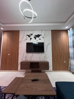 a living room with a flat screen tv on a wall at Cosy appart hotel Bouznika in O Ben Slimane
