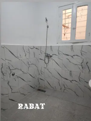 a bathroom with a marble wall with a window at Hachem in Rabat