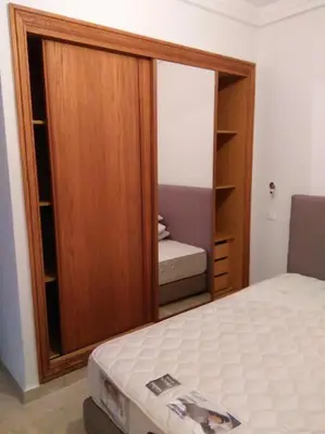 a bedroom with a bed and a wooden closet at Home Stay Casa in Casablanca