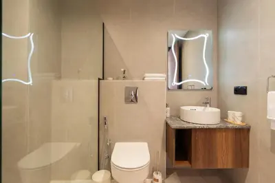 a bathroom with a toilet and a sink and a mirror at Design 1BR Living Home M5 Stadium Balcony & Private Parking in Maarif