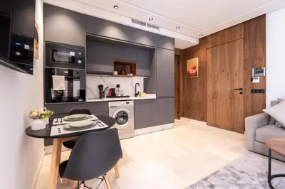 a kitchen and living room with a table and a couch at Design 1BR Living Home M5 Stadium Balcony & Private Parking in Maarif