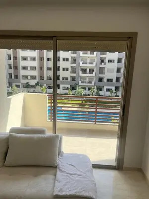 a room with a bed and a large window at Furnished studio with pool in Nouaseur