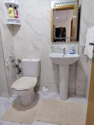 a white bathroom with a toilet and a sink at Aeroport Tissir Appartement in Nouaceur