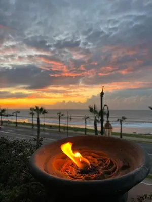 a fire pit on the beach with a sunset in the background at Zaouia in Rabat