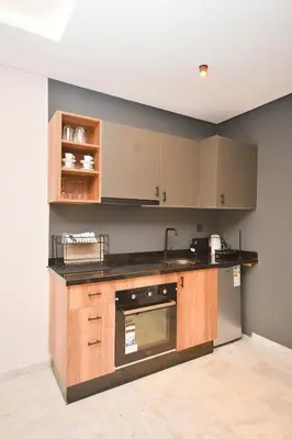 a kitchen with wooden cabinets and a counter top at Atelier Aedes - Studio 1 in Maarif