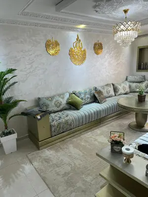 a living room with a couch and chandeliers at Ahmed 205 in Temara