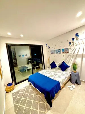a bedroom with a bed with blue sheets and a window at nouveau penthouse en plein centre de casa in Casablanca