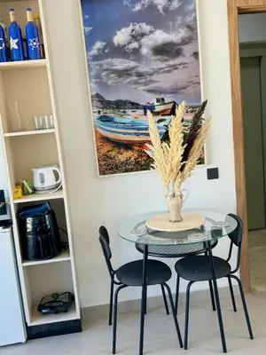 a table with two chairs and a painting on the wall at nouveau penthouse en plein centre de casa in Casablanca
