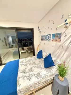 a bedroom with a large bed with blue pillows at nouveau penthouse en plein centre de casa in Casablanca