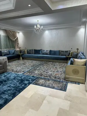 a living room with a blue couch and a rug at McDonalds Apartment 2 Mars in Casablanca