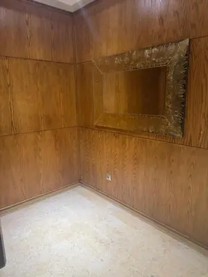 an empty room with wooden walls and a television at Appartement Sara in Mohammedia