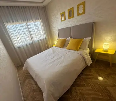 a bedroom with a bed with yellow pillows and a window at Cosy Stay 15min from Casablanca Airport, in Berrechid in Berrechid