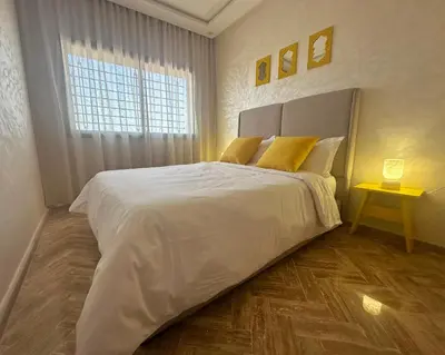 a bedroom with a large white bed and a window at Cosy Stay 15min from Casablanca Airport, in Berrechid in Berrechid
