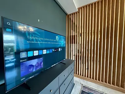 a large flat screen tv in a room with a wooden wall at AeroRelax, free Parking, WI-FI in Nouaseur