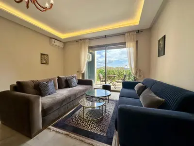 a living room with two couches and a glass table at AeroRelax, free Parking, WI-FI in Nouaseur
