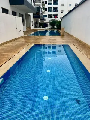 an empty swimming pool with blue tiles in a building at W&M LUXOR residence TEMARA in Temara