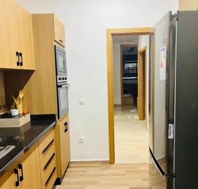 a kitchen with a refrigerator and a hallway at W&M LUXOR residence TEMARA in Temara