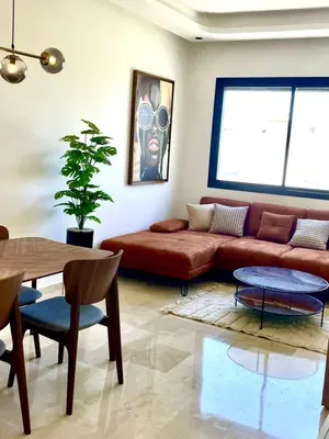 a living room with a brown couch and a table at Maarif Picasso Studio & Private Terrace & Parking in Casablanca