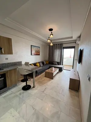 a living room with a couch and a table at Ocean park zenata in Aïn Harrouda