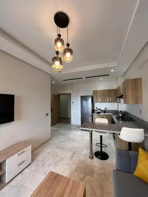 a living room with a table and a kitchen at Ocean park zenata in Aïn Harrouda