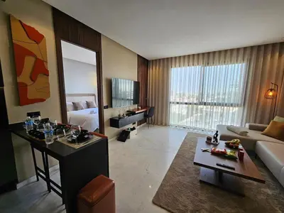 a living room with a room with a couch and a table at Central Luxurious & Great Location Ultra Fast Wi-Fi In The Heart Of Casablanca Oasis Disrict With A City View in Casablanca