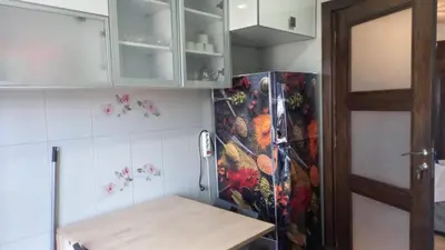 a kitchen with a refrigerator and a table in it at Bel appartement in Mohammedia
