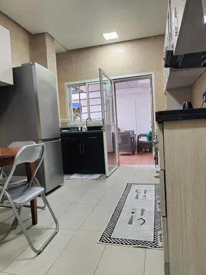 a kitchen with a table and a chair and a door at Charming apartment agdal rabat in Rabat
