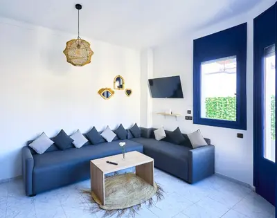 a living room with a blue couch and a table at Suite BD ANFA - Queen Bed & Private Balcony in Casablanca
