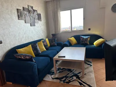 a living room with a blue couch and a table at Signorina appartamento in Temara