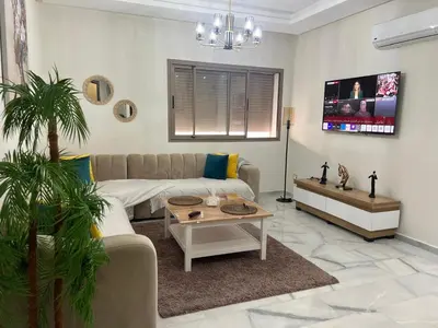 a living room with a couch and a table at Parc mohammedia in Mohammedia