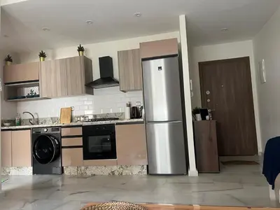 a kitchen with a refrigerator and a dishwasher at Parc mohammedia in Mohammedia