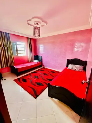 a bedroom with a red bed and a red rug at familly house in Tamaris