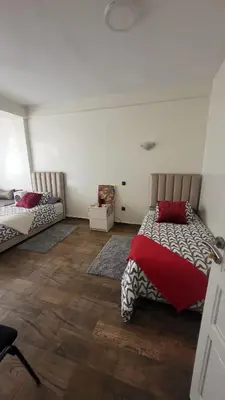 a bedroom with two beds with red pillows at Cozy home in a good location in Mohammedia