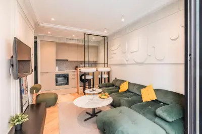 a living room with a green couch and a table at Le Claridge - Cosy Studio - By Mi-Haven in Casablanca