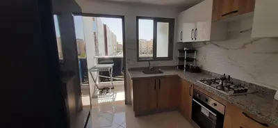 a kitchen with a sink and a stove top oven at Appartement lumineux près de la plage de Sidi Bouzid in El Jadida