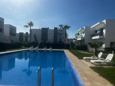 a swimming pool with lounge chairs in front of a building at Villa Blanca - by Nero in Sidi Rahal
