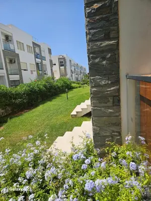 a garden with flowers next to a building at Appartement Harhoura La vallée pas loin de Arzana hotel in Temara