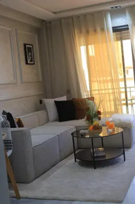 a living room with a white couch and a table at Charmant studio au cœur de Maarif - Confort balcon et emplacement idéal in Casablanca
