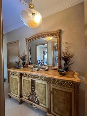 a bathroom with a wooden dresser with a mirror at Appartement Skhirat , vue sur mer in Skhirat