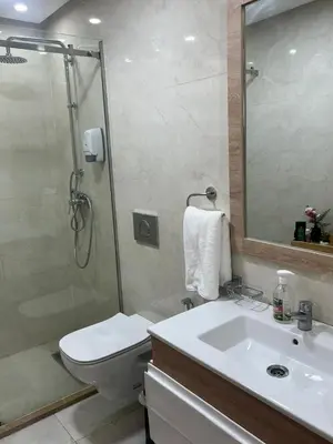 a bathroom with a shower and a toilet and a sink at appartement de lux vue piscine 5 min plage bouznika in Bouznika