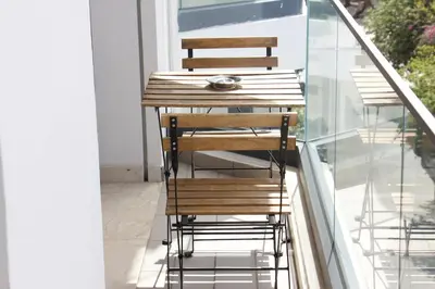 a wooden table and chairs on a balcony at Chic & central in Maarif