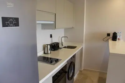 a small white kitchen with a sink and a stove at Chic & central in Maarif