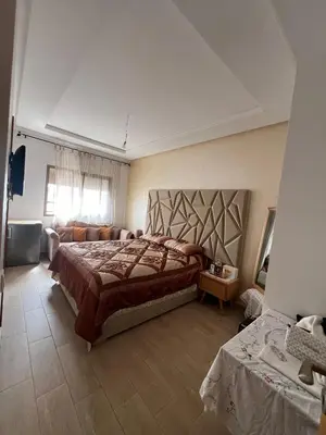 a bedroom with a large bed and a couch at Les jardins d'Atlantis Dar Bouazza in Tamaris
