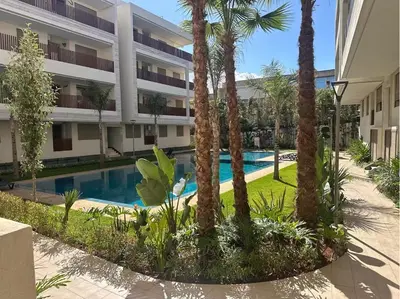 a hotel with a swimming pool in front of a building at Évasion luxueuse avec piscine proche de la mer in Mohammedia