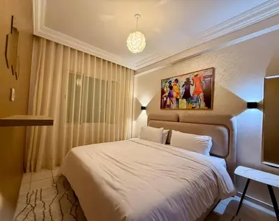 a bedroom with a white bed and a painting on the wall at Apartment Majorelle Garden in Casablanca