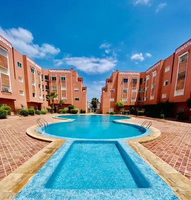 a swimming pool in the middle of a courtyard with buildings at logement entier familly house in Tamaris
